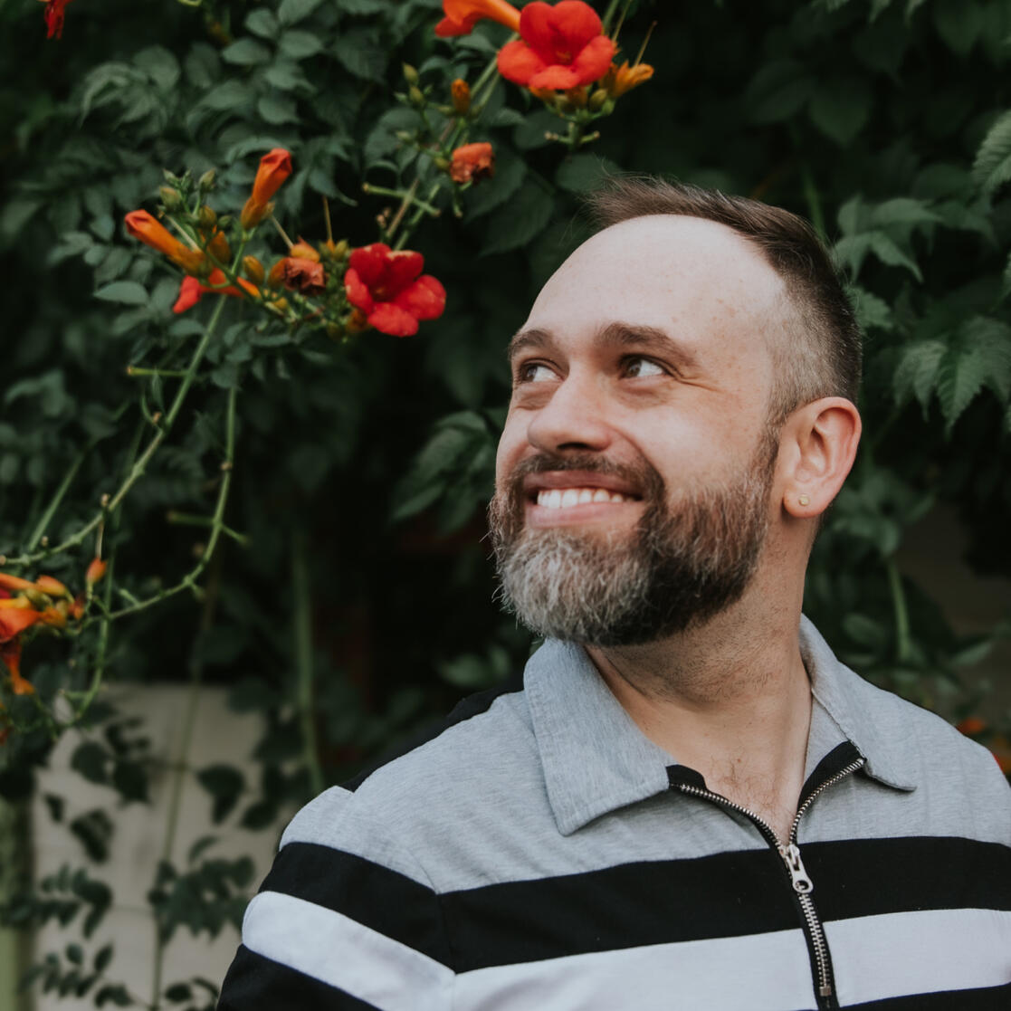 Ian Nichols, coach and astrologer, smiling and looking upward outdoors